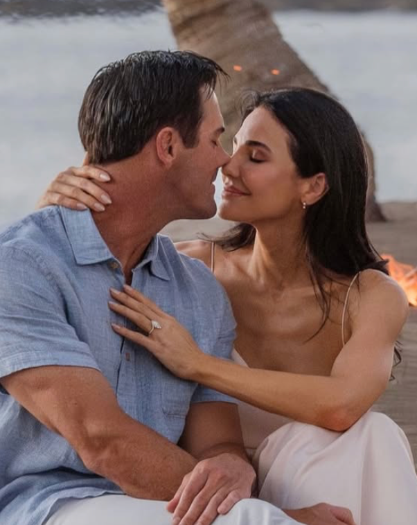 Cole Hamels and Rebekah Graf at a beach sitting together 